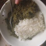 A green spinach like food with rice.